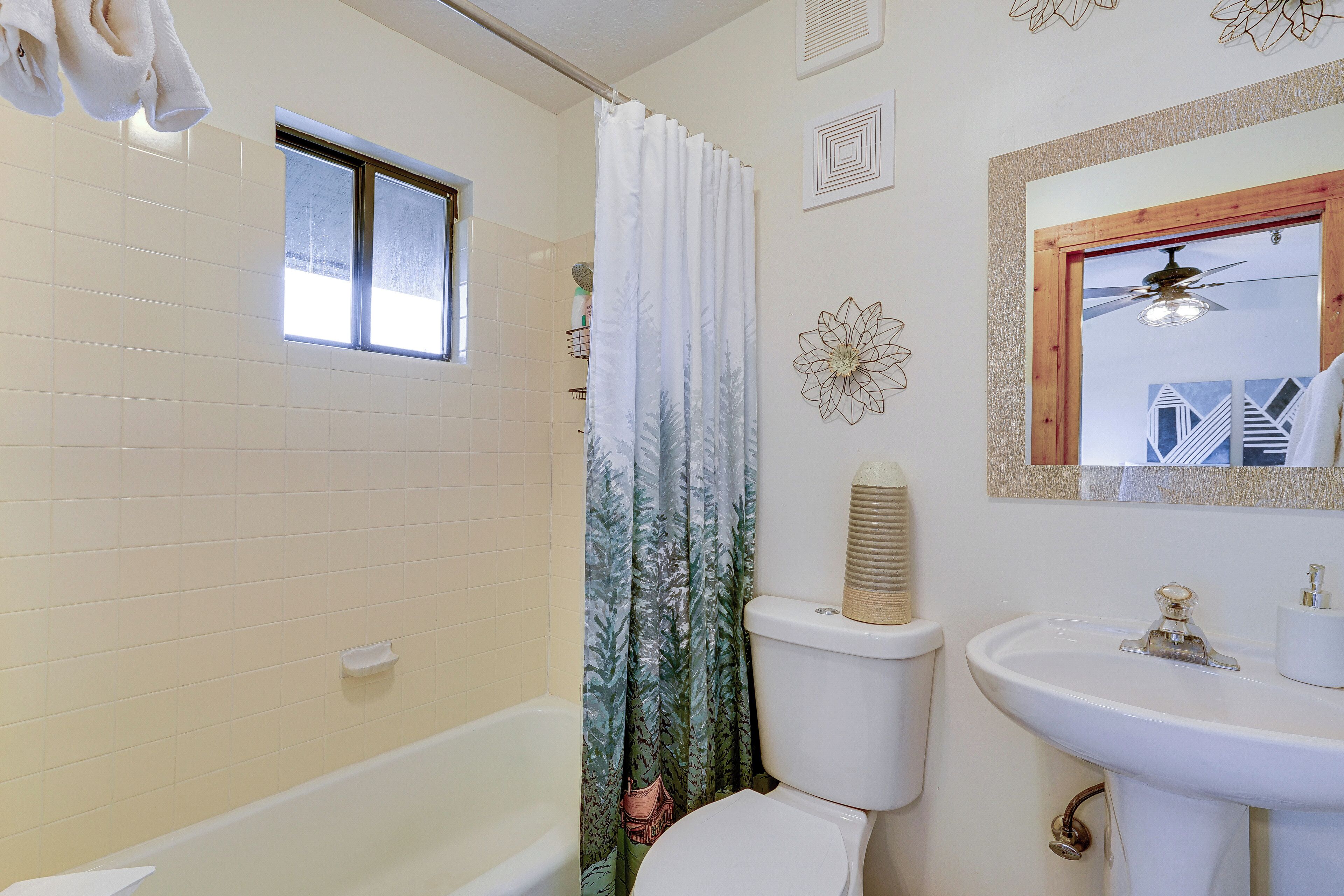 A bathroom with a bathtub, toilet, and sink.