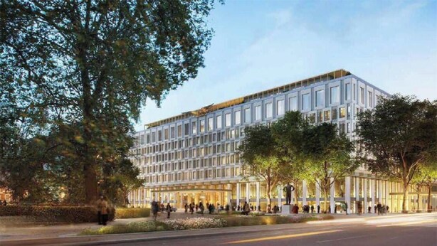 A modern hotel with a rectangular facade, large windows, and a central entrance with a statue.
