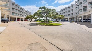 Un hôtel moderne à plusieurs étages, doté d’une cour intérieure agrémentée d’arbres et d’un parking couvert.