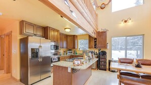 A spacious kitchen with wooden cabinets, stainless steel appliances, and a large island. - 5 Mi to Kasilof River: Forest-view Retreat w/ Deck (Kasilof)