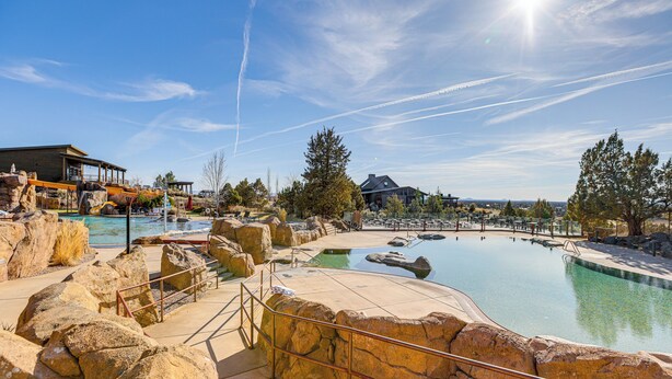 A resort with a large outdoor pool, rock formations, and a clear blue sky. - Mountain-view Cabin Near Trails in Powell Butte! (Powell Butte)