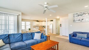 A living room with a blue sofa, a wooden coffee table, and a ceiling fan. - Walk to Beach: Wildwood Apt w/ Balcony! (Wildwood)