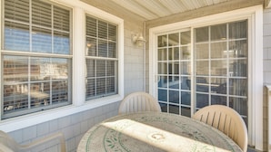A sunlit patio with a round table and chairs, large windows, and a view of the city. - Walk to Beach: Wildwood Apt w/ Balcony! (Wildwood)