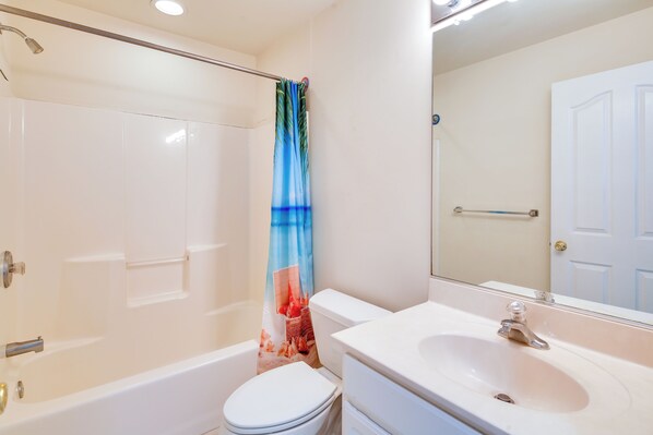A bathroom with a bathtub, toilet, and sink. - Walk to Beach: Wildwood Apt w/ Balcony! (Wildwood)