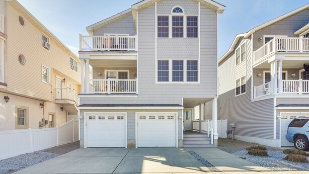 A two-story residential building with a central entrance, a covered front porch, and a garage. - Walk to Beach: Wildwood Apt w/ Balcony! (Wildwood)