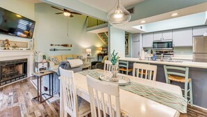 A modern kitchen with a dining area, a fireplace, and a staircase. - 7 Mi to The Wharf: Gem w/ Beach Access (Orange Beach)