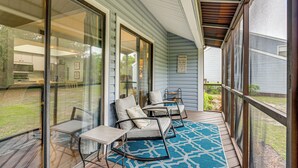 A covered porch with outdoor furniture, a blue patterned rug, and a view of the backyard. - 7 Mi to The Wharf: Gem w/ Beach Access (Orange Beach)