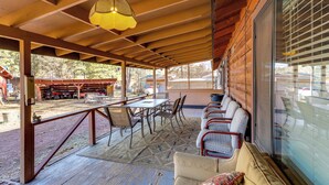 A covered outdoor seating area with a table and chairs, a sofa, and a hanging light fixture. - 16 Mi to Mogollon Rim: Home w/ Deck in Payson! (Payson)