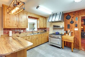 A kitchen with wooden cabinets, a stove, and a sink. - 16 Mi to Mogollon Rim: Home w/ Deck in Payson! (Payson)