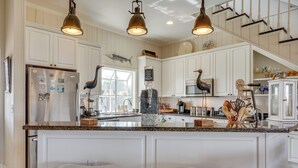 A kitchen with white cabinetry, a granite countertop, and pendant lighting. - Marina & Golf Course Views: Edisto Island Home (Edisto Island)