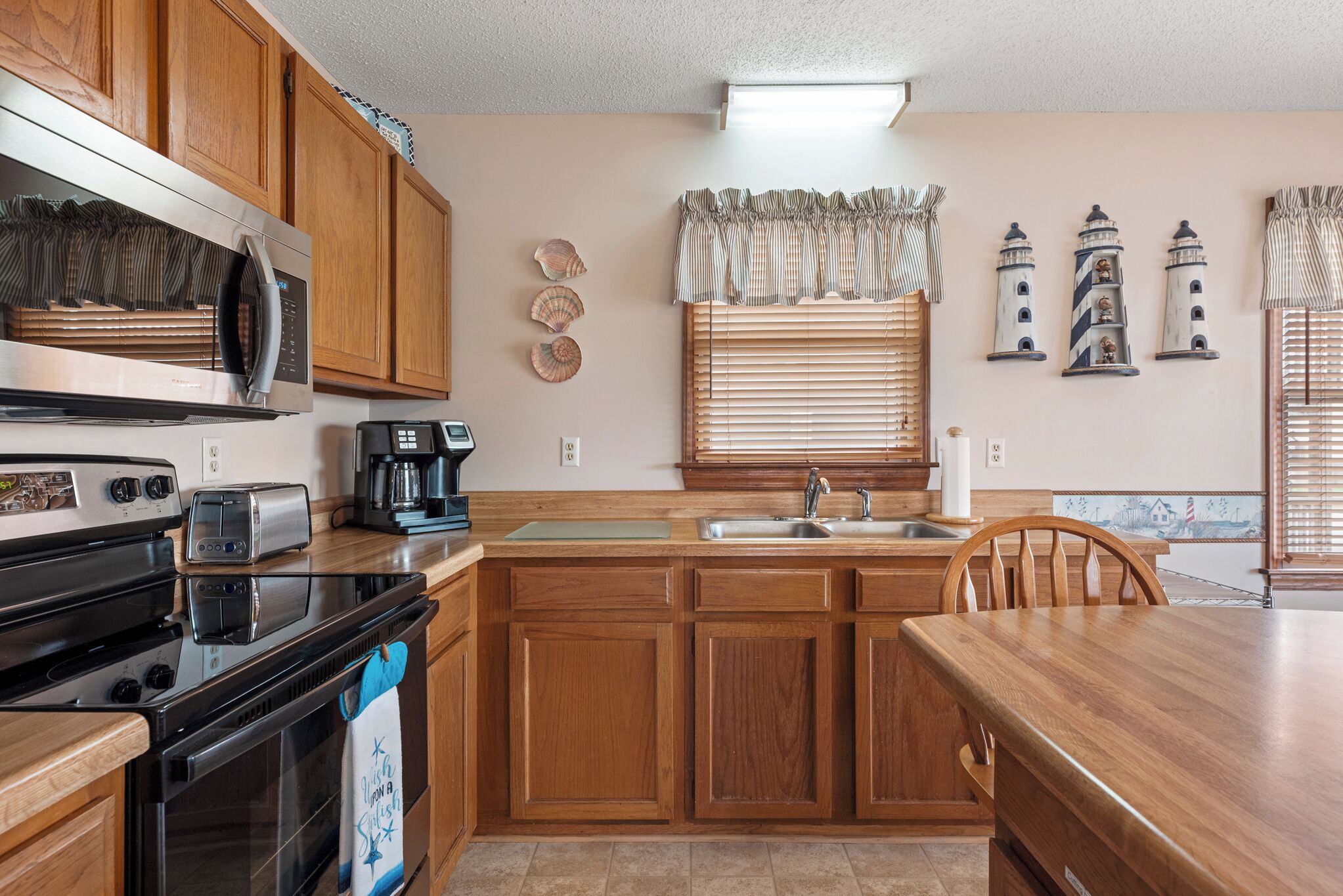 A kitchen with wooden cabinets, a stainless steel microwave, a toaster, and a coffee maker.