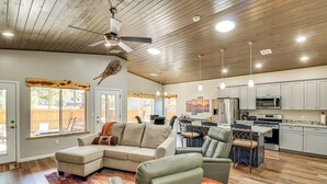 A spacious living area with a sectional sofa, a dining table, and a kitchen with modern appliances. - Hot Tub & Outdoor Living: Relaxing Show Low Cabin (Show Low)