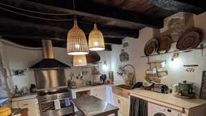 Una cocina con piso de cuadros, estufa, pileta y lavadora.