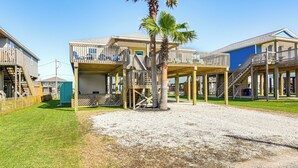 A beachfront hotel with multiple balconies, a palm tree, and a clear sky. - 1 Block to Surfside Beach: Home w/ Gulf Views! (Freeport)