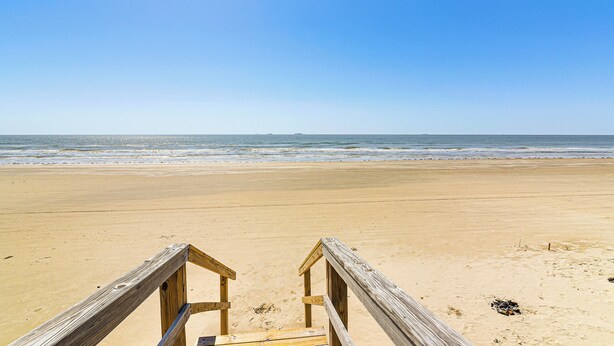 A wooden boardwalk leading to a sandy beach with a clear blue sky. - 1 Block to Surfside Beach: Home w/ Gulf Views! (Freeport)