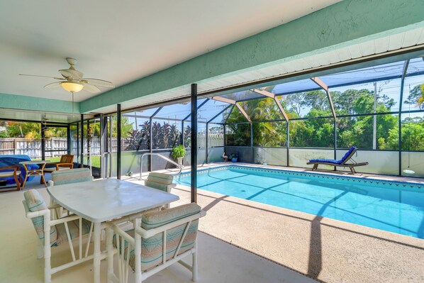 A pool area with a table and chairs, a ceiling fan, and a view of the surrounding greenery. - 2 Mi to Water: Sebastian Home w/ Pool! (Sebastian)