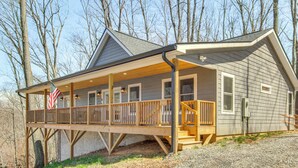 A two-story cabin with a covered porch and a flagpole. - Modern Retreat w/ Mtn Views in Maggie Valley! (Maggie Valley)