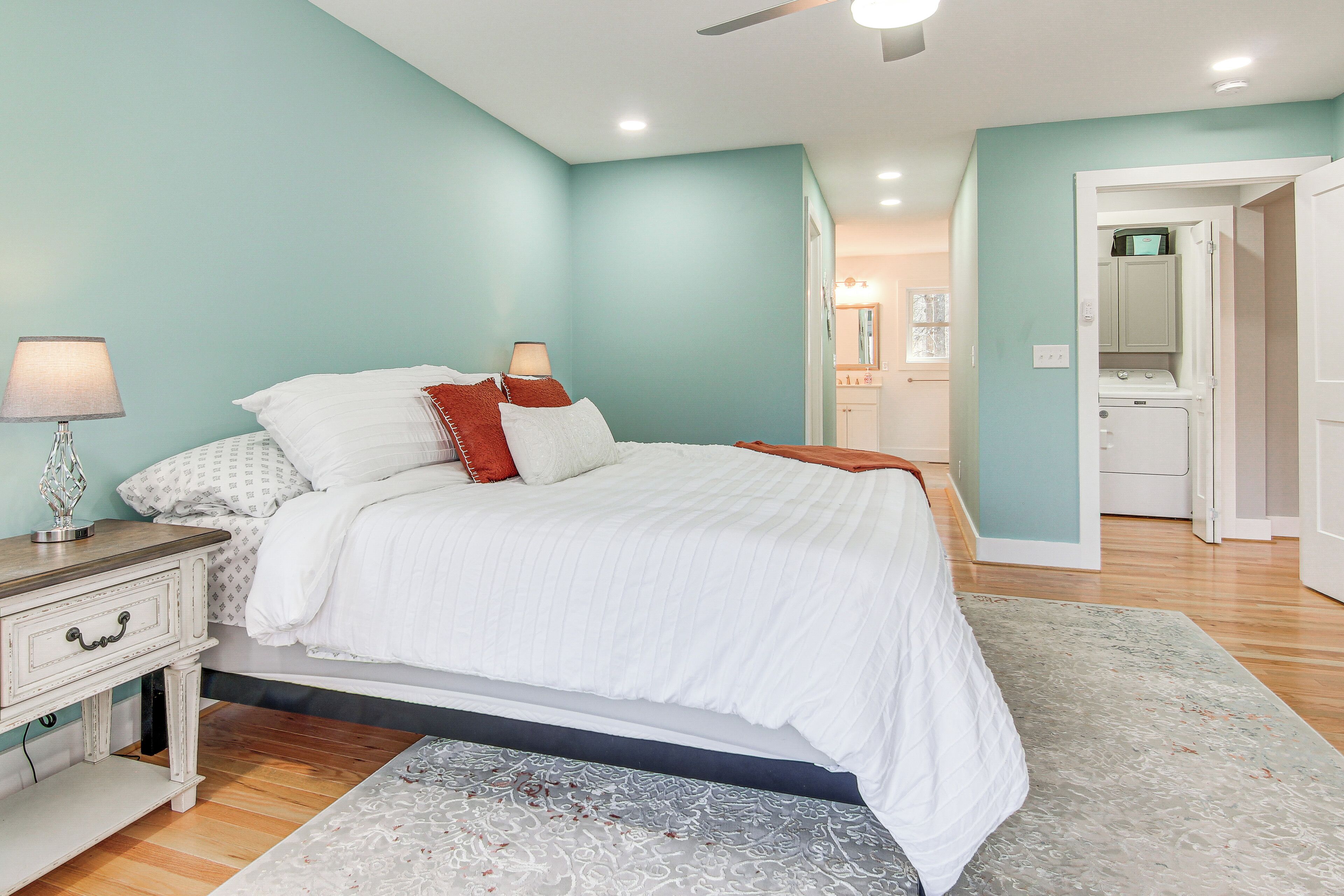 A bedroom with a bed, bedside tables, a lamp, and a walk-in closet.