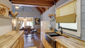 A wooden kitchen with a sink, wooden countertops, and a dining area with a table and chairs. - Fish On-site: Okeechobee Cabin w/ Pool Access (Okeechobee)