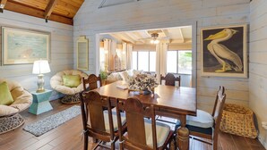 A dining area with a wooden table, chairs, and a vase of flowers. - Fish On-site: Okeechobee Cabin w/ Pool Access (Okeechobee)