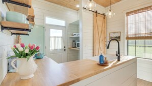 A kitchen with wooden countertops, a white sink, and a hanging light fixture. - Contrell Cottage On Farm w/ Peaceful Views (Lena)