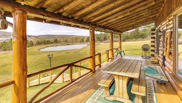 Eine Holzterrasse mit Picknicktischen mit Blick auf einen See.