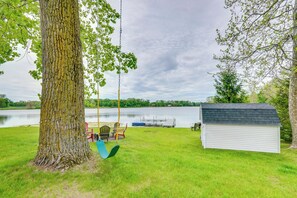 A swing set, a small shed, and a dock extending into a lake. - Lakefront Getaway w/ Fire Pit in Akron (Akron)