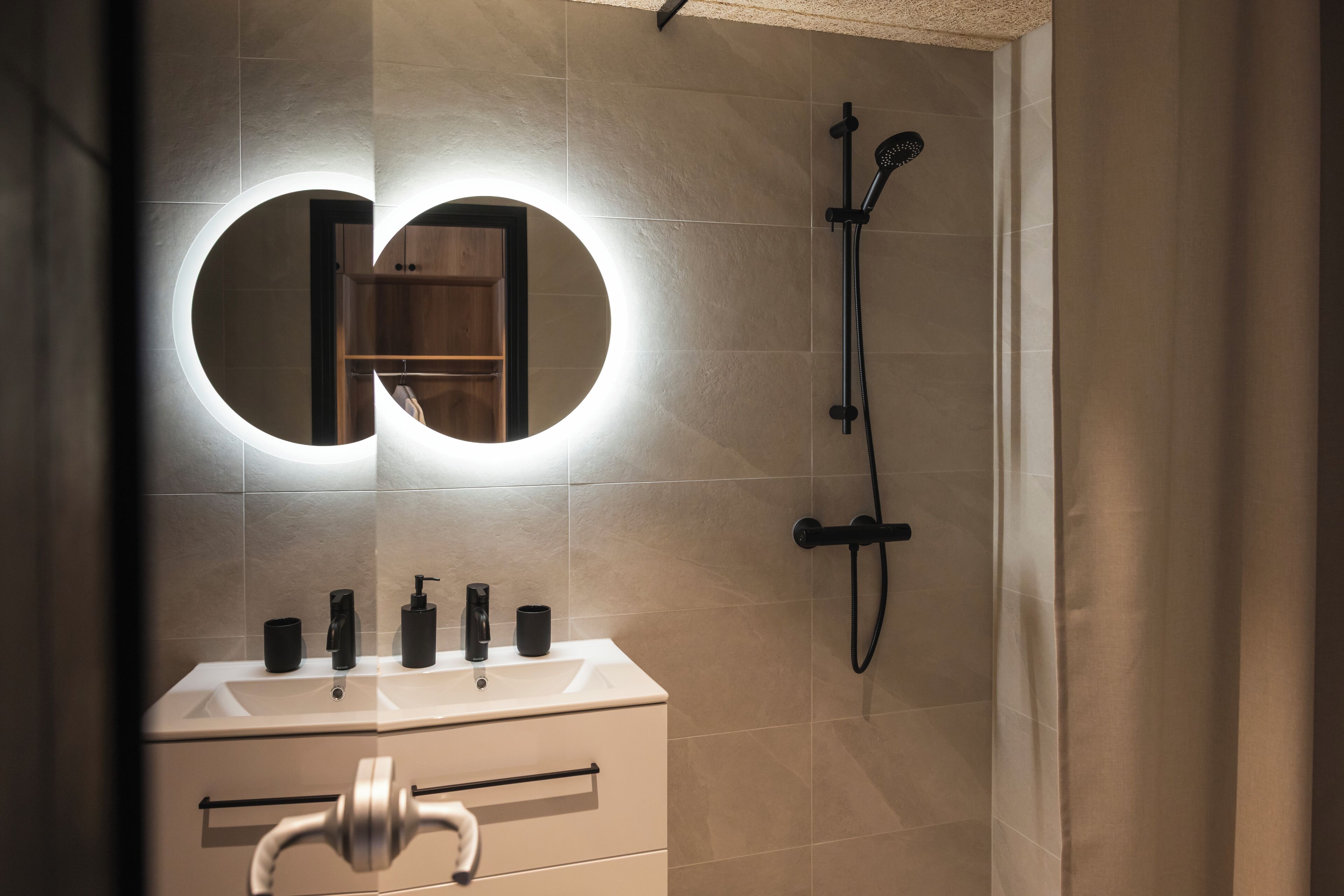 Un baño con espejo, lavabo y ducha.
