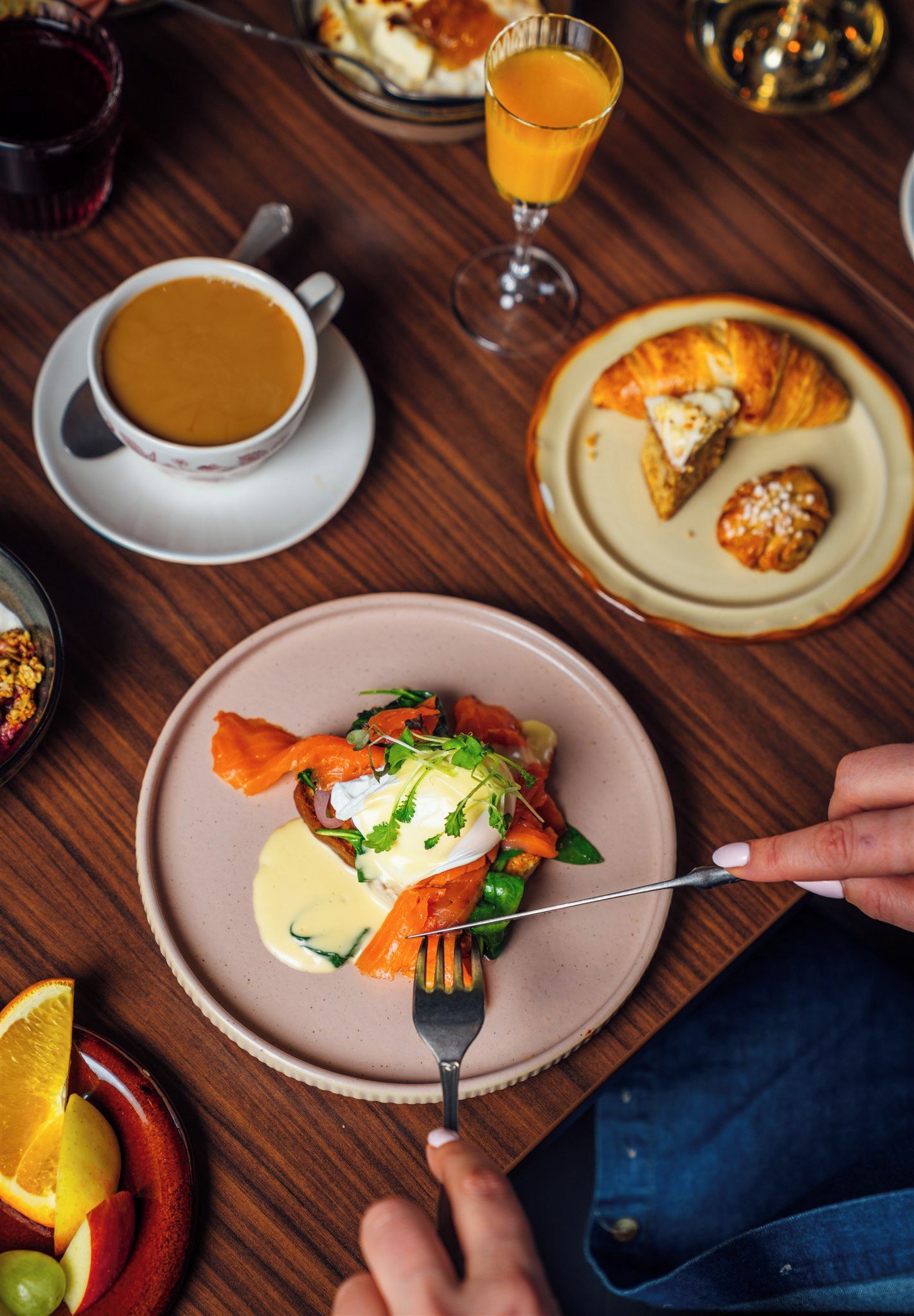 A dining table with a plate of food, a glass of orange juice, and a cup of coffee.