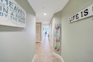 Un couloir avec une pancarte « Bienvenue », une autre pancarte indiquant « La vie, c’est… » et une troisième pancarte qui dit : « Le paradis est un peu plus proche dans une maison au bord de l’eau. »