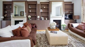 Un salon avec une cheminée, deux canapés, une table basse et une bibliothèque.