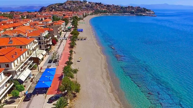 A coastal town with a long beach, clear blue waters, and buildings with red-tiled roofs. - Seaside Astros Getaway - La Maison Etoile (North Kynouria)