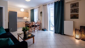 A modern apartment with a dining area, kitchen, and living room. - Seaside Astros Getaway - La Maison Etoile (North Kynouria)