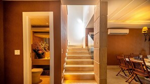 A staircase leading to a dining area with wooden flooring and a table set for four. - Bz91 Centro 600m Rua das Pedras piscina (Buzios)