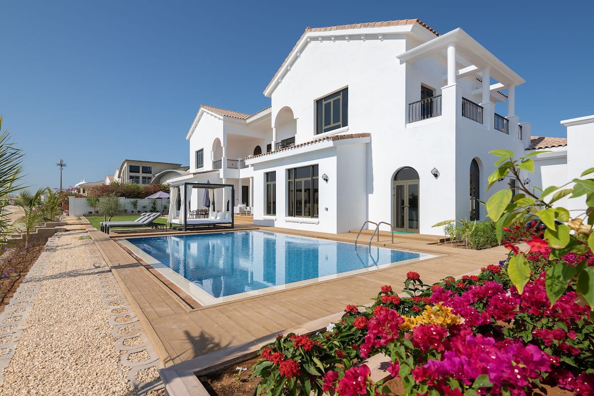 A modern villa with a swimming pool, a covered patio, and a well-maintained garden.