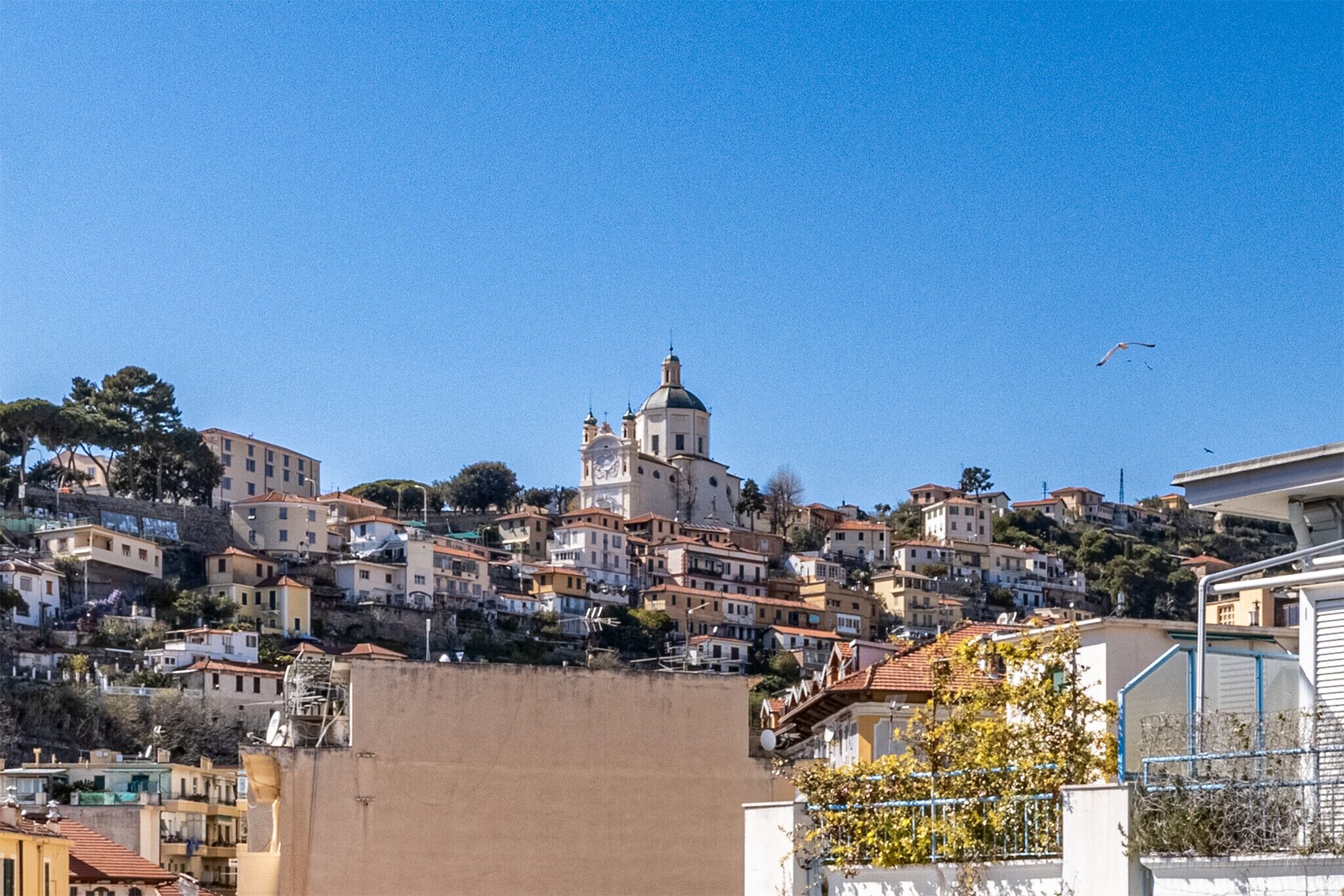 Un pueblo en una ladera con una iglesia destacada y edificios residenciales.