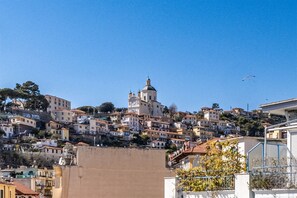 A hillside town with a prominent church and residential buildings. - Sea View Central Apartment by Wonderful Italy (Sanremo)