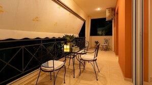Un coin repas avec une table dressée pour quatre personnes, entourée de chaises, et une plante en pot posée sur la table.