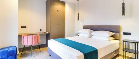 A modern hotel room with a large bed, a desk, and a chair.