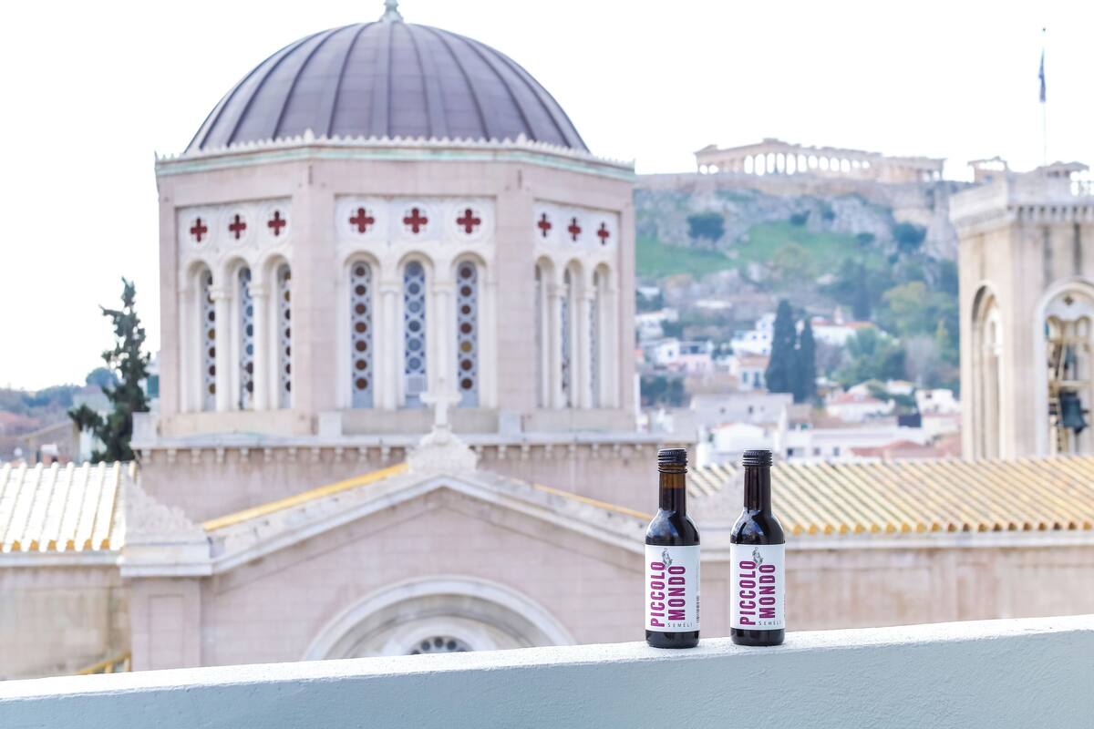 Une vue d’un bâtiment doté d’un dôme et de croix, ainsi que de deux bouteilles de vin sur un balcon.