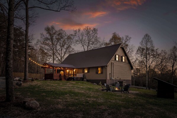 A house with a covered porch, a fire pit, and a small deck.