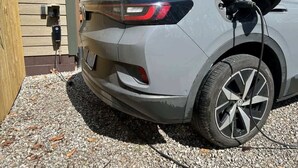 Un vehículo estacionado frente a un edificio con un enchufe a la vista.