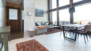 A spacious living area with a sofa, coffee table, and dining table. - Villa Halla 2, HimosYkkösen alue (Jämsä)