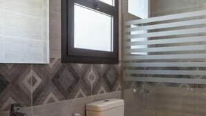 Un baño con lavamanos, inodoro y ducha.