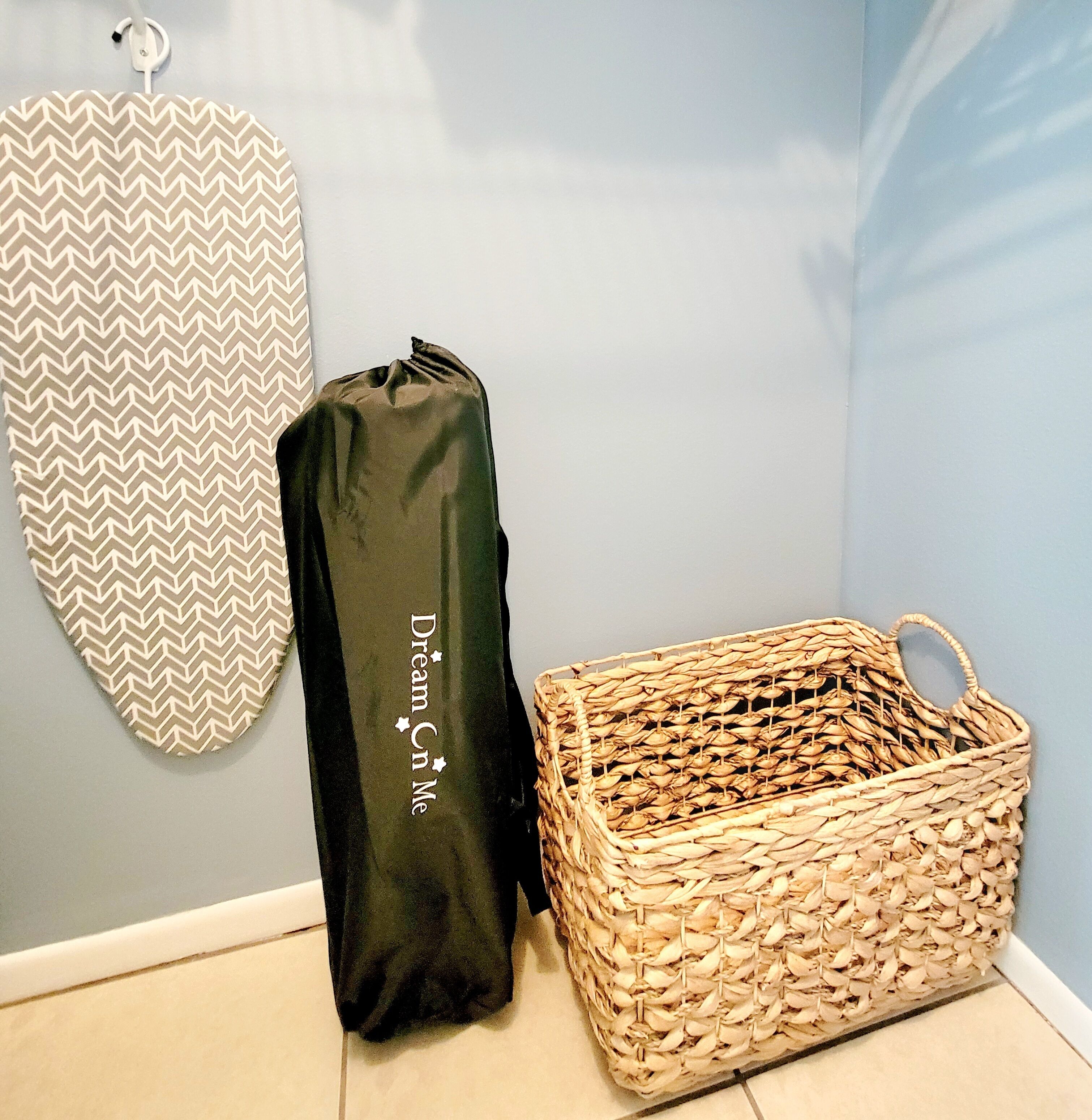 Une pièce avec un panier tressé et un sac noir sur lequel est inscrit le texte « Dream Cn Me ».