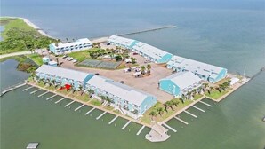Luftaufnahme eines Küstenhotels mit mehreren Gebäuden, einer Marina und einem Steg.