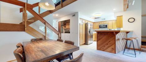 A spacious kitchen with wooden cabinets, a built-in island, and a stainless steel refrigerator.