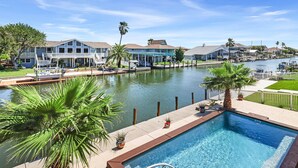 A residential area with a swimming pool, waterfront views, and houses with balconies. - Bon Bini 4 Bedroom Home (Rockport)