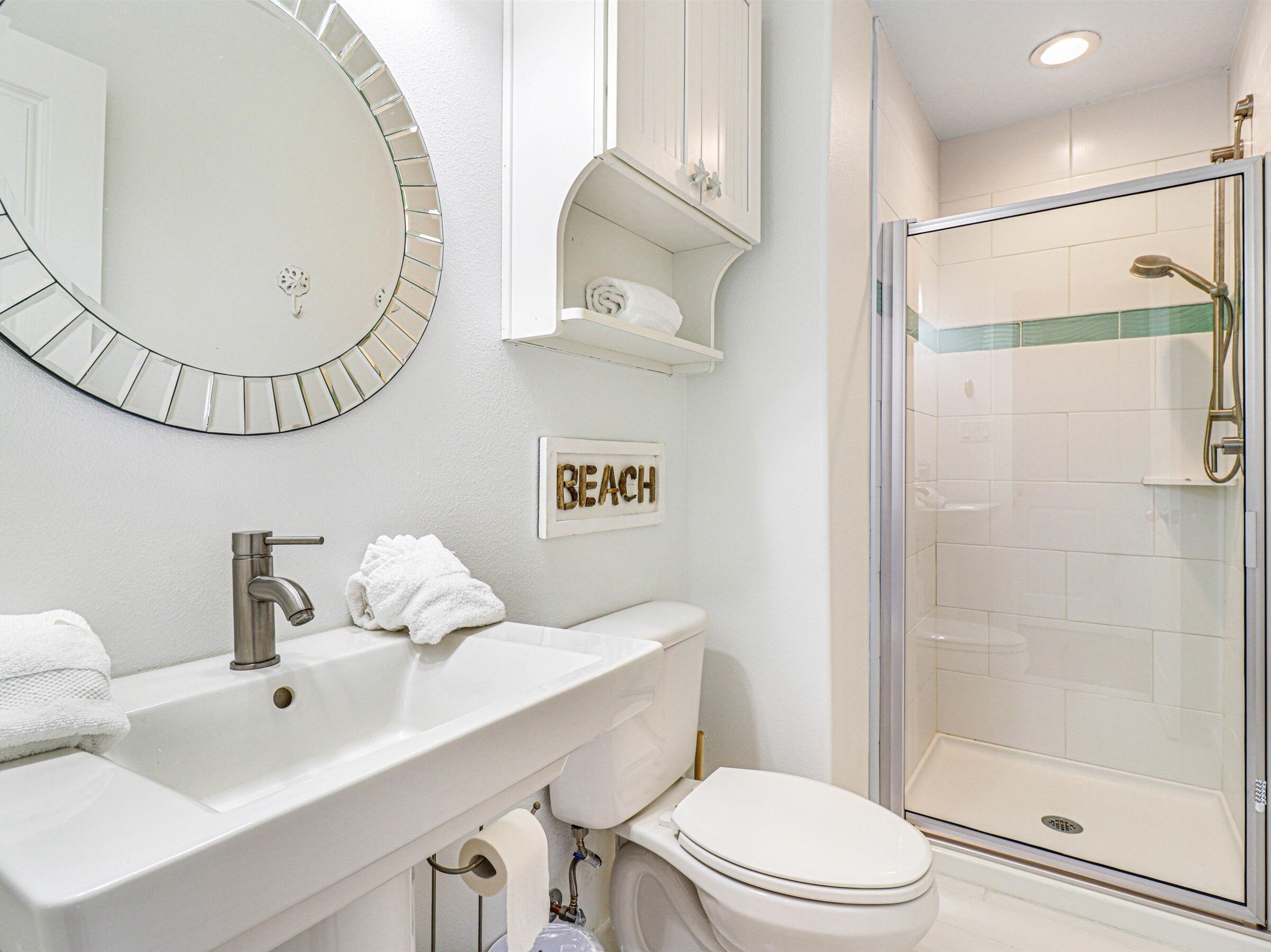 A modern bathroom with a sink, toilet, and glass-enclosed shower.