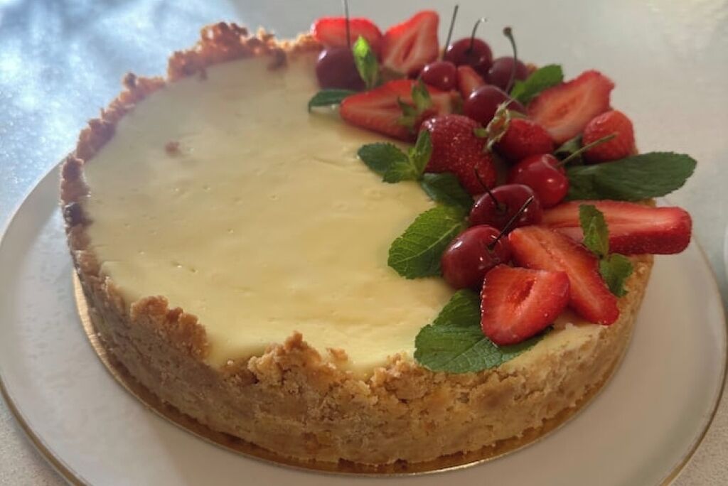 Un gâteau au fromage garni de fraises et de cerises.